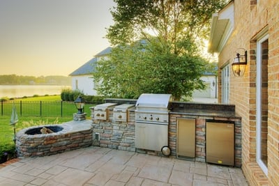Slide-in grill encased in stone, power burners, accessories, and stone fire pit