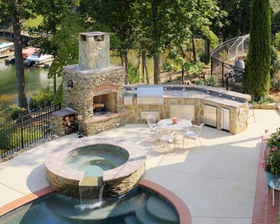 Custom stone patio & outdoor kitchen with built-in grill, accessories, and fireplace